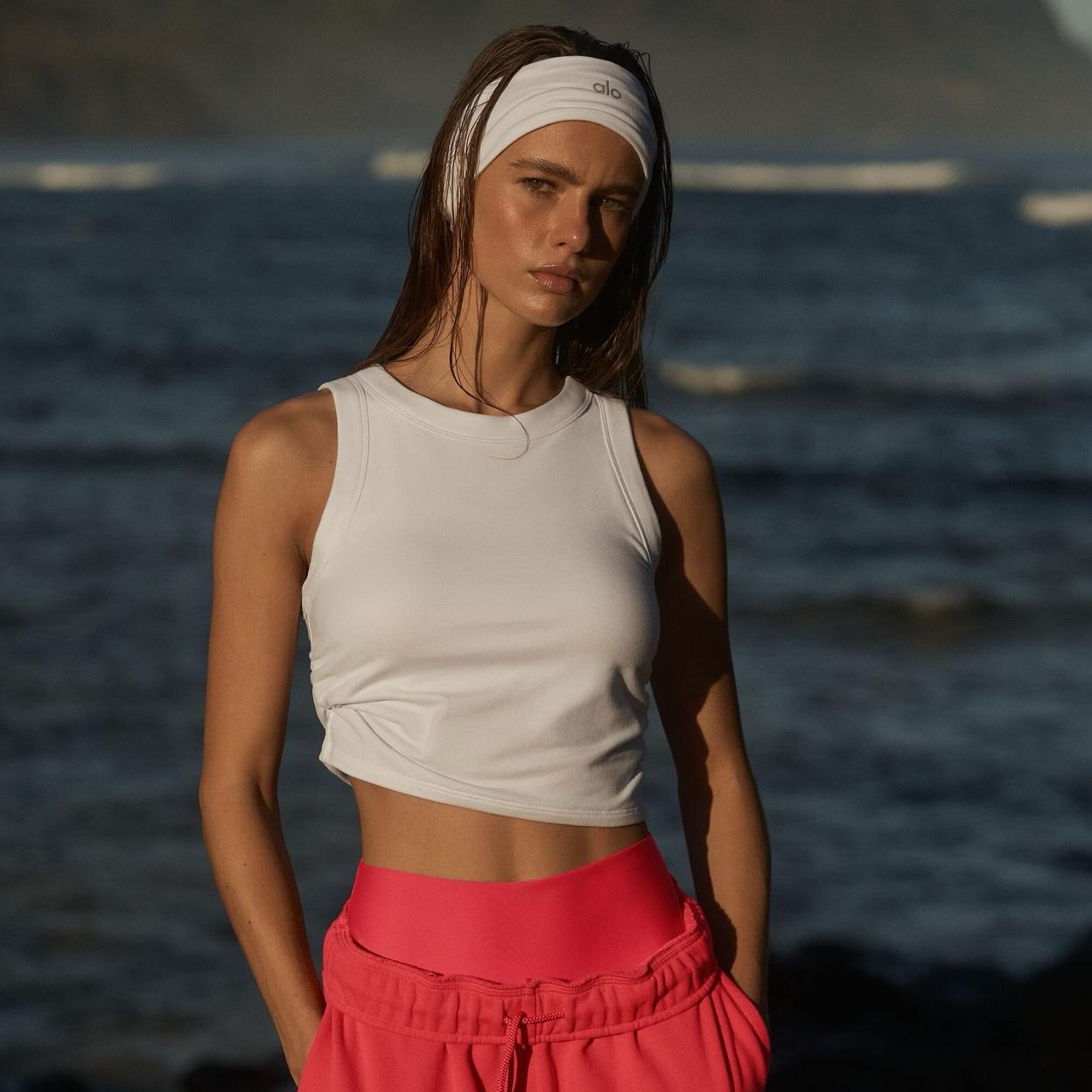 Mujer con un look deportivo en la playa. 