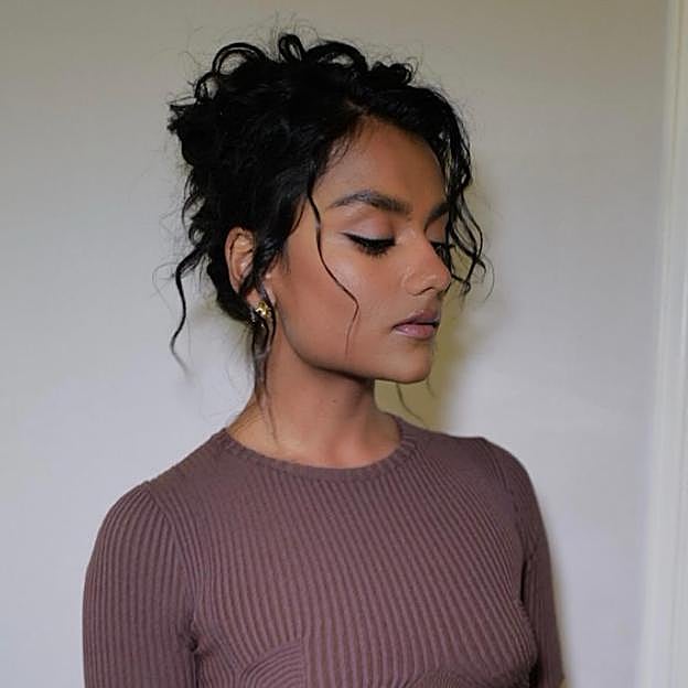 Simone Ashley con el pelo rizado largo.