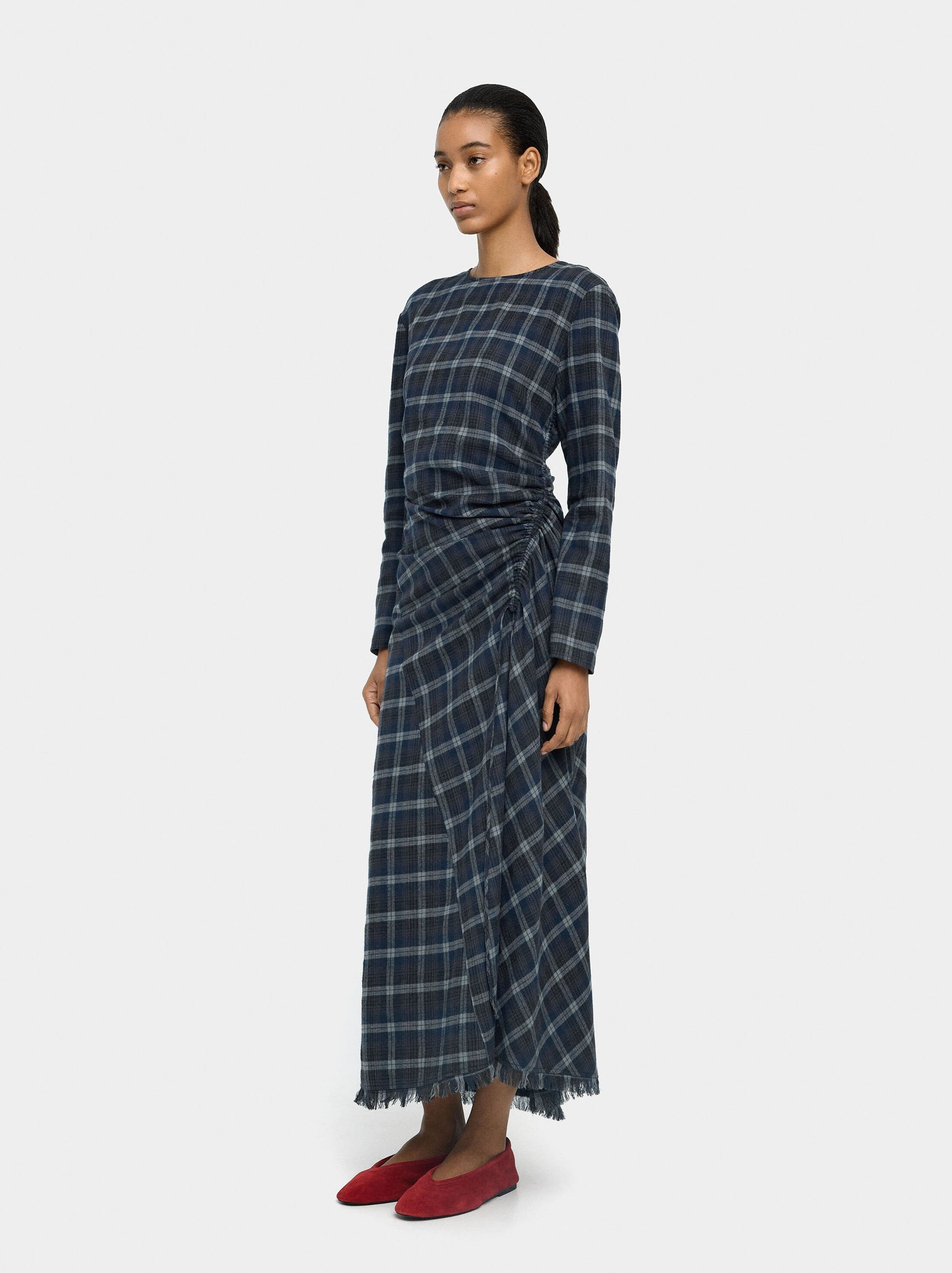 Es un vestido con drapeado en la cintura.