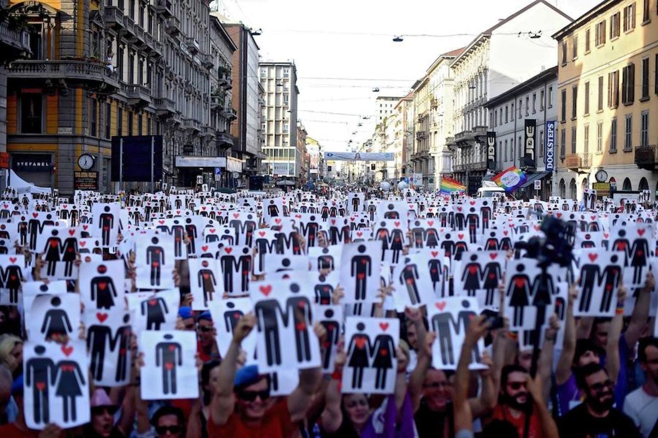 Participantes de la Marcha del Orgullo Gay en Milán muestran carteles de figuras masculinas y femeninas.