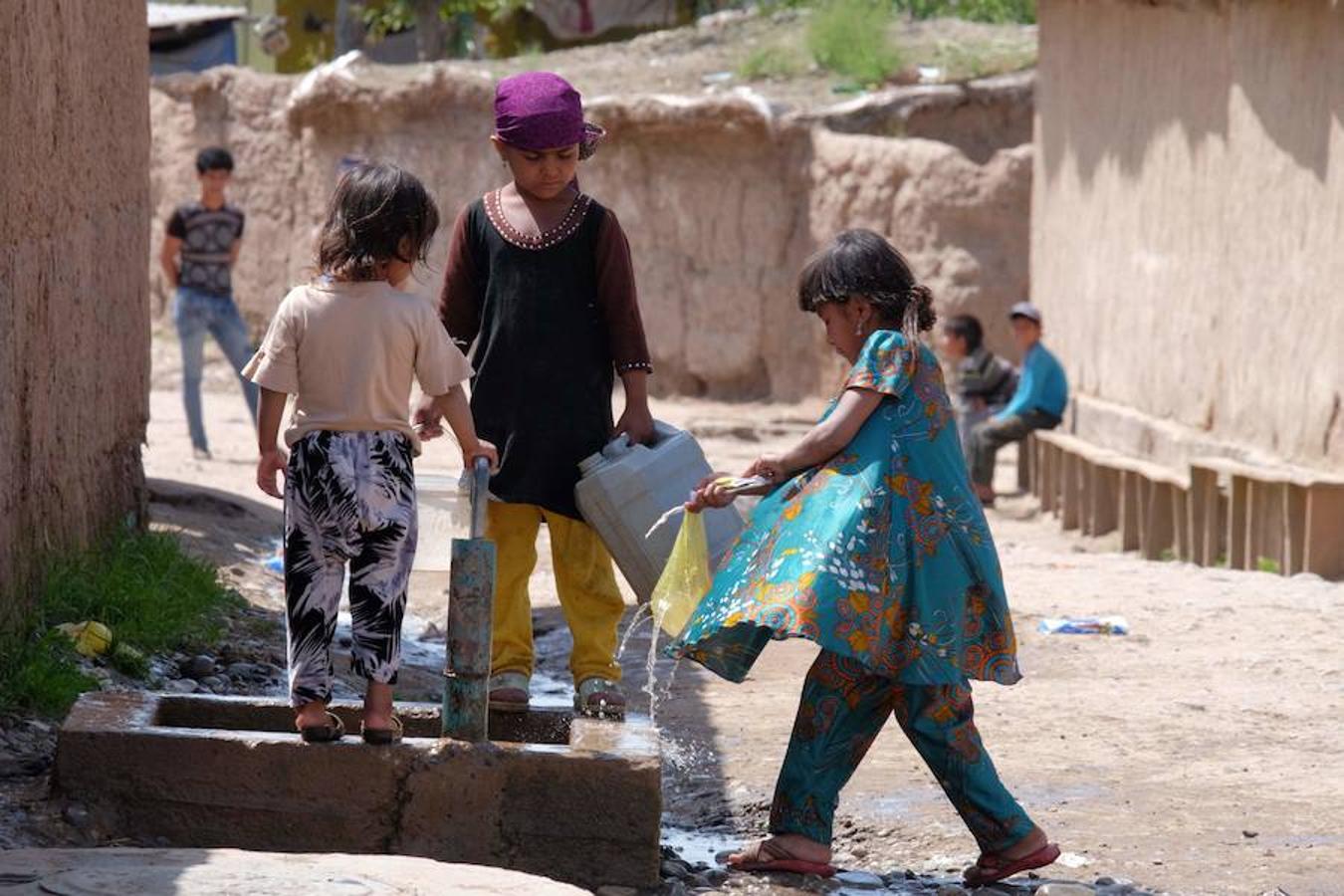 Niños que recogen agua de un grifo comunal en un asentamiento en la región de Khatlon, Tayikistán.