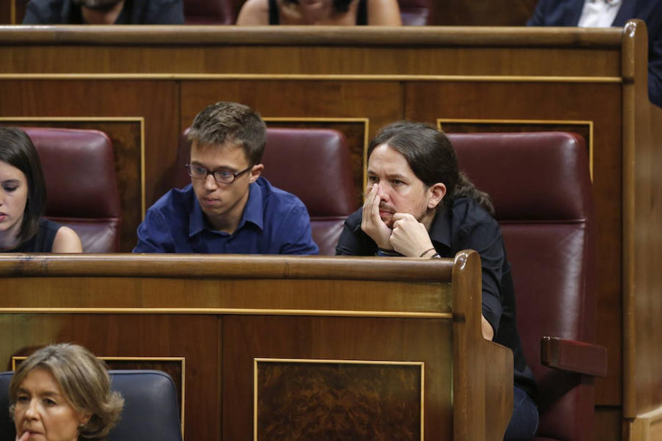 El secretario general de Podemos, Pablo Iglesias (d), y el portavoz parlamentario, Iñigo Errejón (i), escuchan hoy desde su escaño el discurso de investidura.
