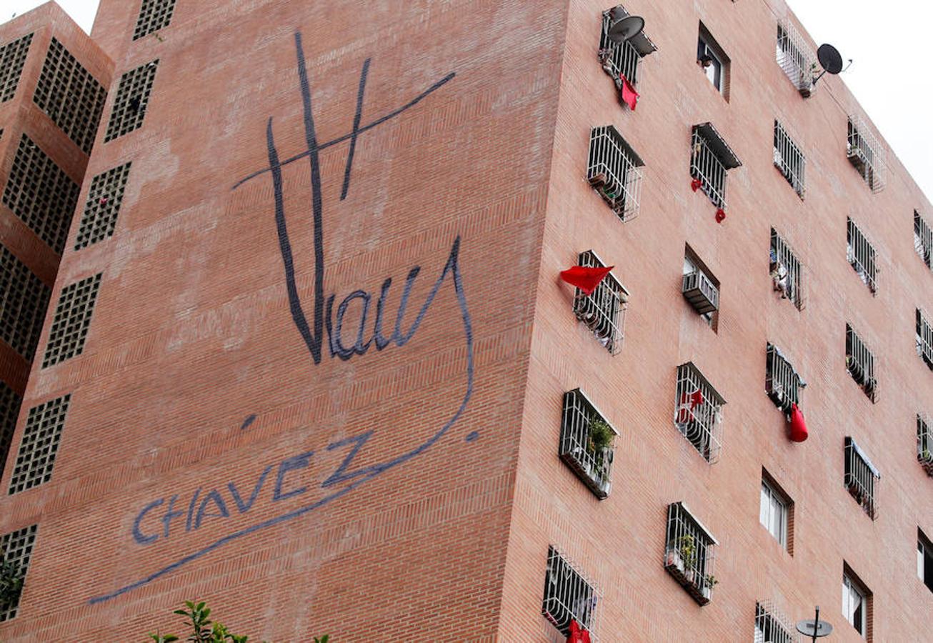 Los partícipes del gobierno sacan las camisetas rojas por las ventanas en señal de apoyo a Maduro.