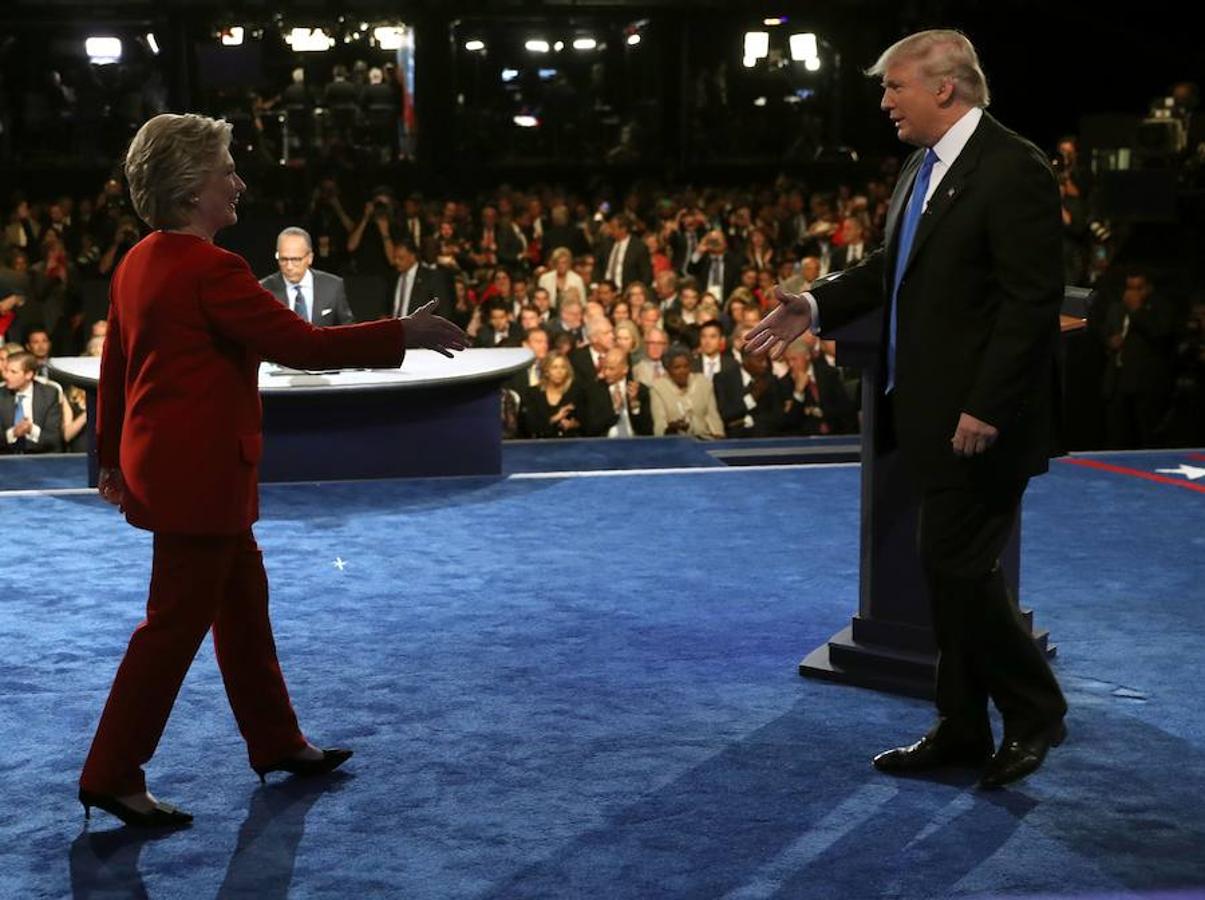 Clinton y Trump se saludan.