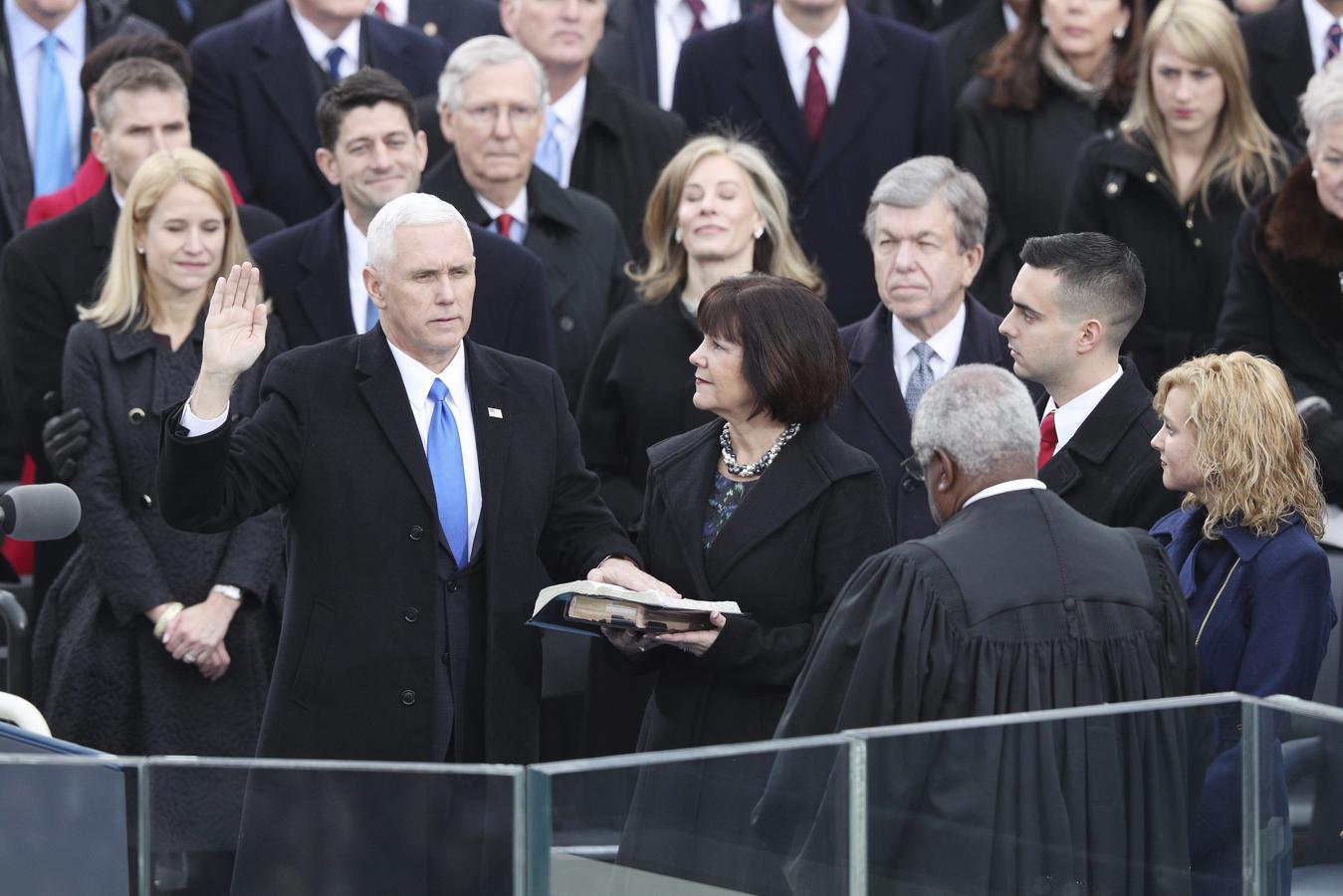 El vicepresidente electo Mike Pence realiza su juramento ante la biblia.