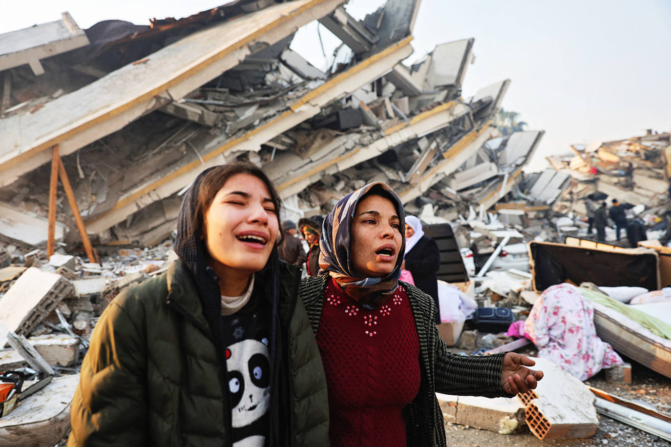 Dos mujeres no dan crédito a lo que sus ojos ven cerca de los escombros tras el terremoto en Hatay, Turquía. / UMIT BEKTAS (REUTERS)