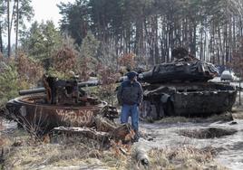 Un hombre observa blindados rusos destruidos a las afueras de Kiev