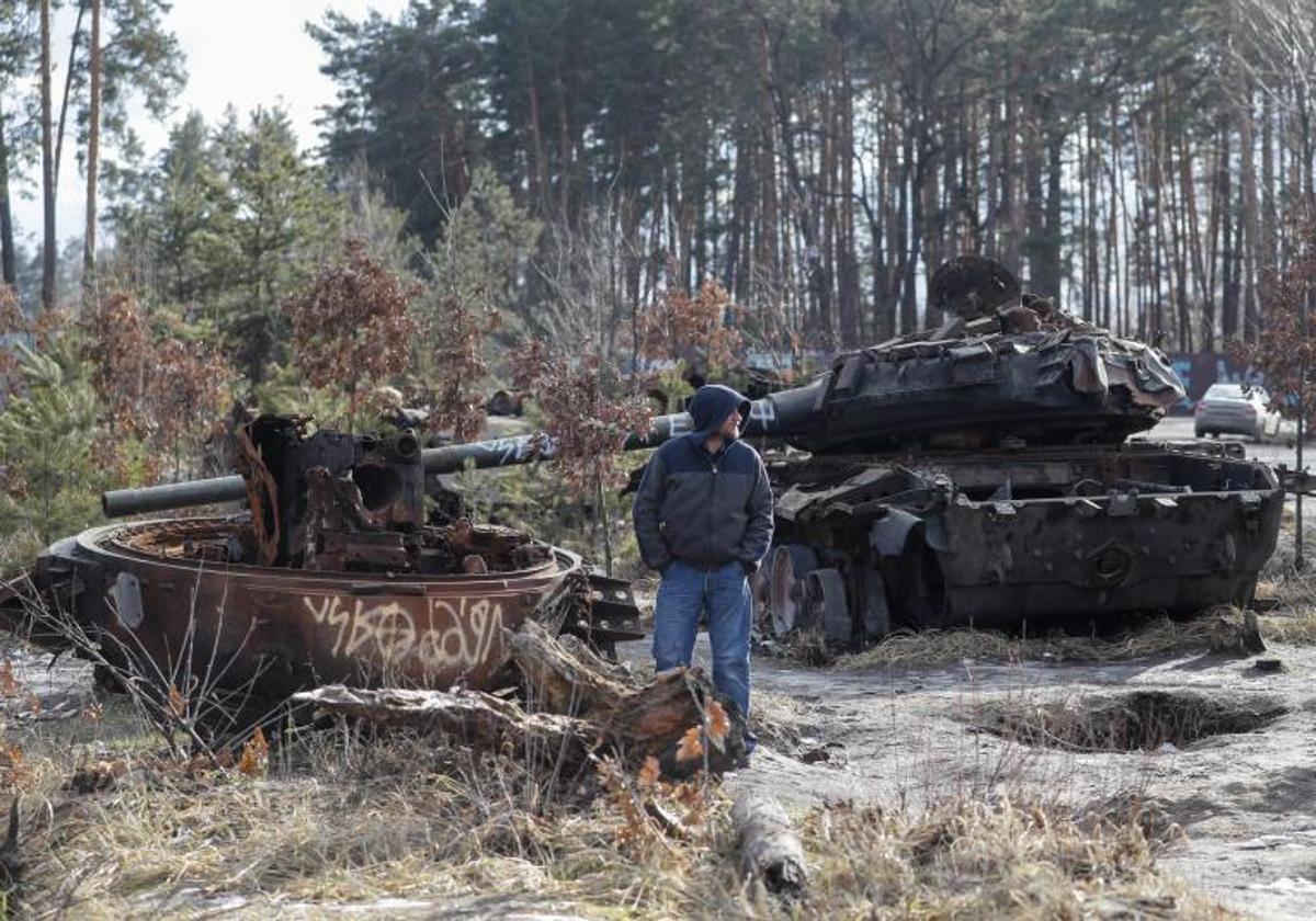 Un hombre observa blindados rusos destruidos a las afueras de Kiev