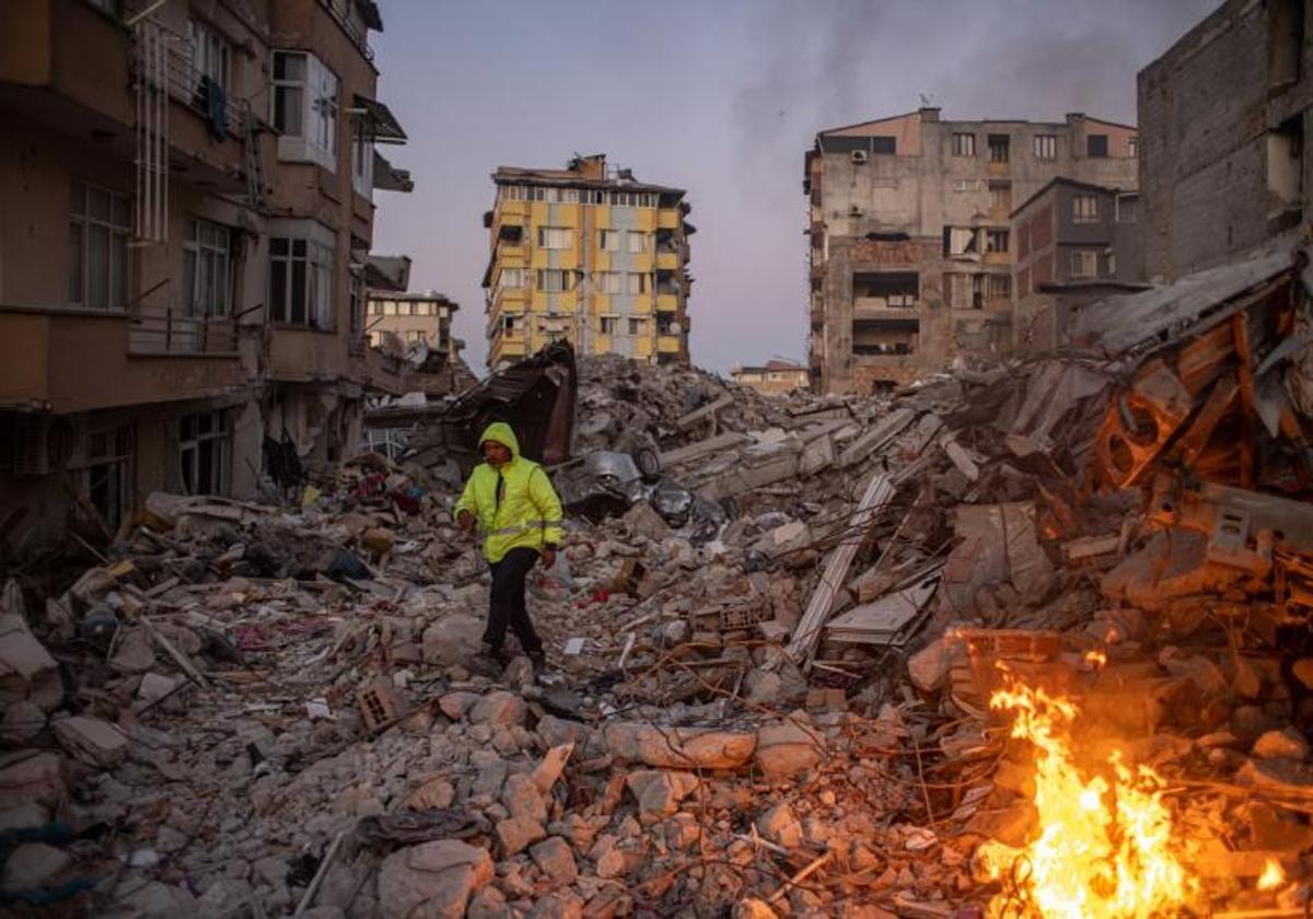 Un hombre camina sobre los escombros de los edificios derrumbados tras el potente terremoto en la localidad turca de Hatay