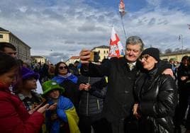 El expresidente ucraniano Petro Poroshenko se fotografía con una admiradora en la cumbre de Múnich.