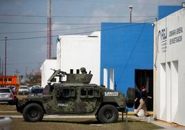 Un vehículo militar vigila la sede del instituto forense donde se depositaron los cadáveres.