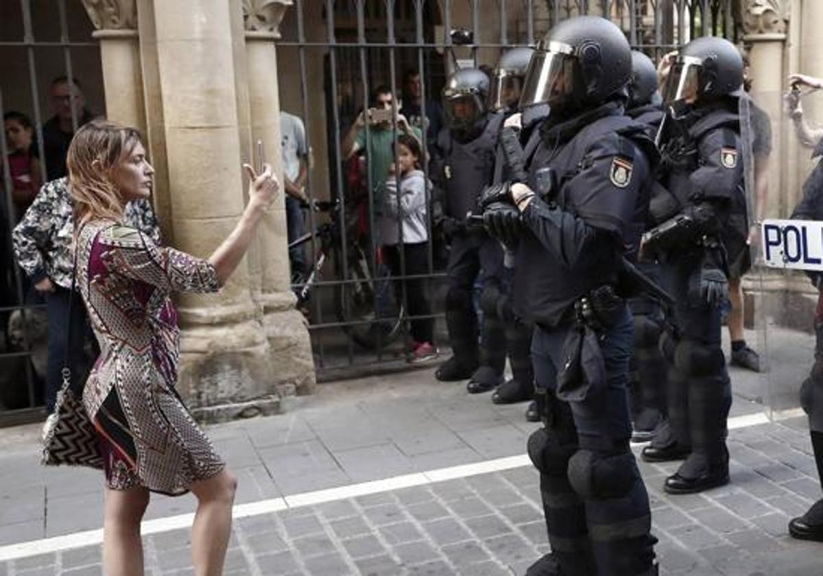 Una mujer graba a un grupo de antidisturbios durante una protesta en Pamplona.