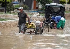 Un hombre camina por una calle inundada de la ciudad de Tumbes.