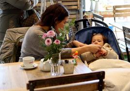 Una madre atendiendo a su bebé en una cafetería