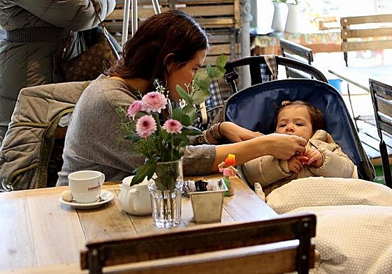 Una madre atendiendo a su bebé en una cafetería