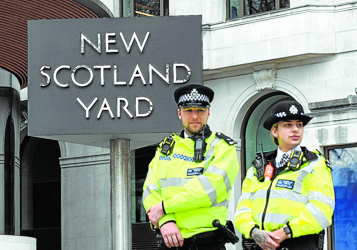 Dos agentes, ante la entrada de la sede de Scotland Yard en Londres.