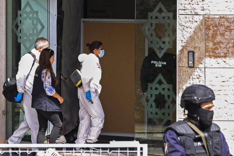 Tres investigadores entran en el centro ismaili de Lisboa donde ha ocurrido el doble crimen.