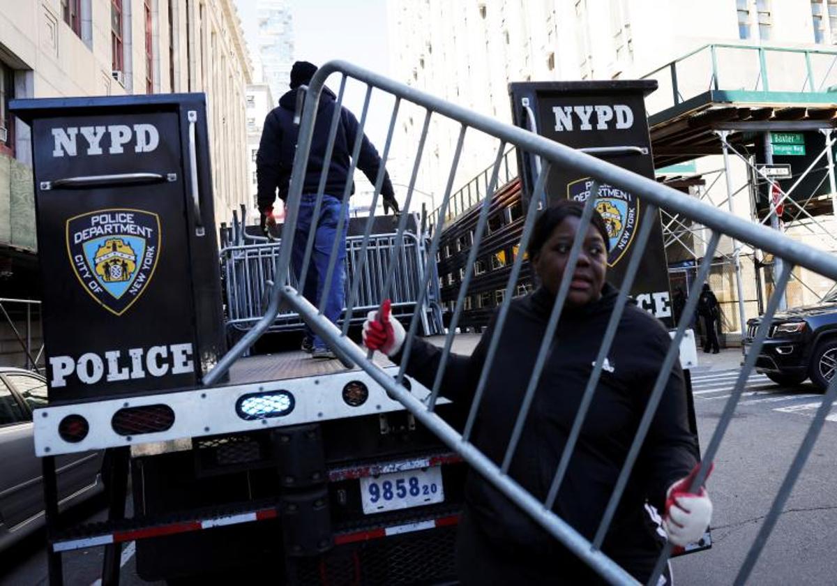 Una agente coloca barricadas en las inmediaciones del tribunal de Manhattan donde deberá comparecer Trump.