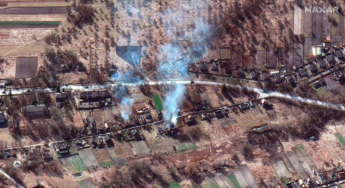 Un grupo de blindados rusos captados por satélite atraviesa una población bombardeada hacia Kiev