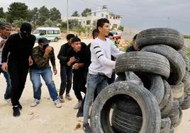 Jóvenes palestinos se parapetan detrás de unos neumáticos en unos enfrentamientos con las fuerzas israelíes en Nablus.