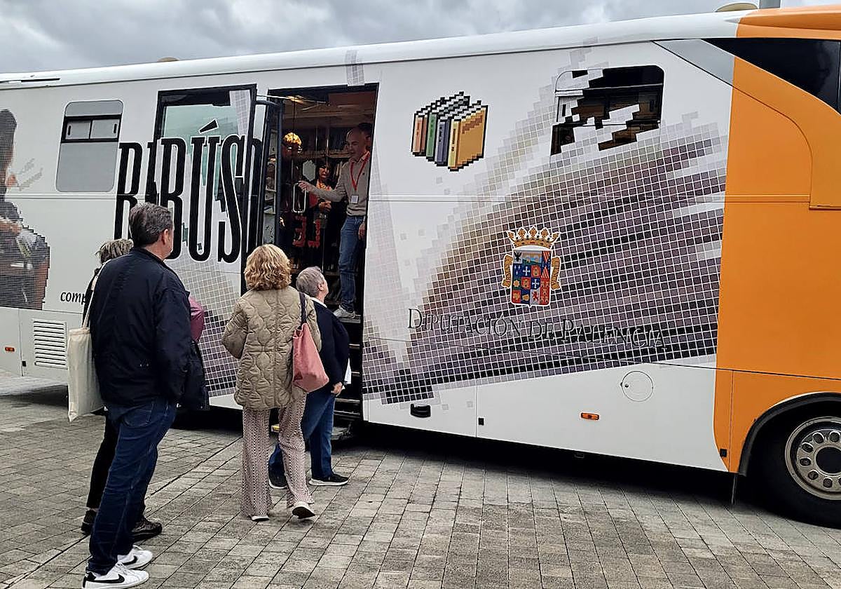 Usuarios de un bibliobús de Palencia aguardan su turno.