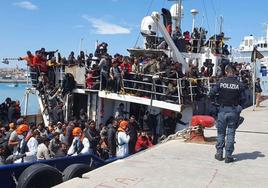 Un policía vigila un barco cargado de migrantes en el puerto siciliano de Catania.