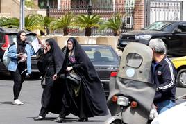 Dos mujeres iraníes caminan en una calle de Teherán