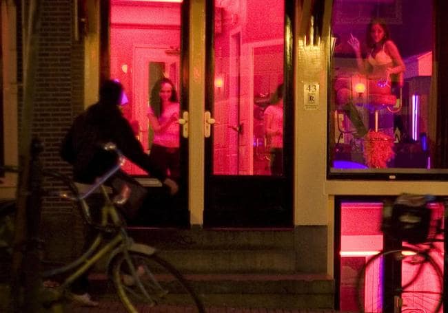 Las mujeres ofrecen sus servicios sexuales dentro de los escaparates iluminados con luces rojas desde que se legalizó la actividad en el año 2000 en Países Bajos
