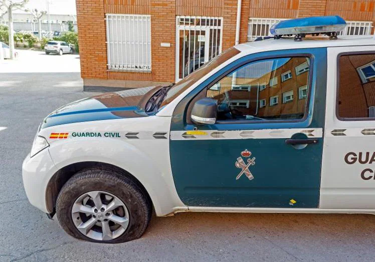 Imagen principal - El coche de la Guardia con los impactos de bala y la gasolinera donde se han producido los hechos. 