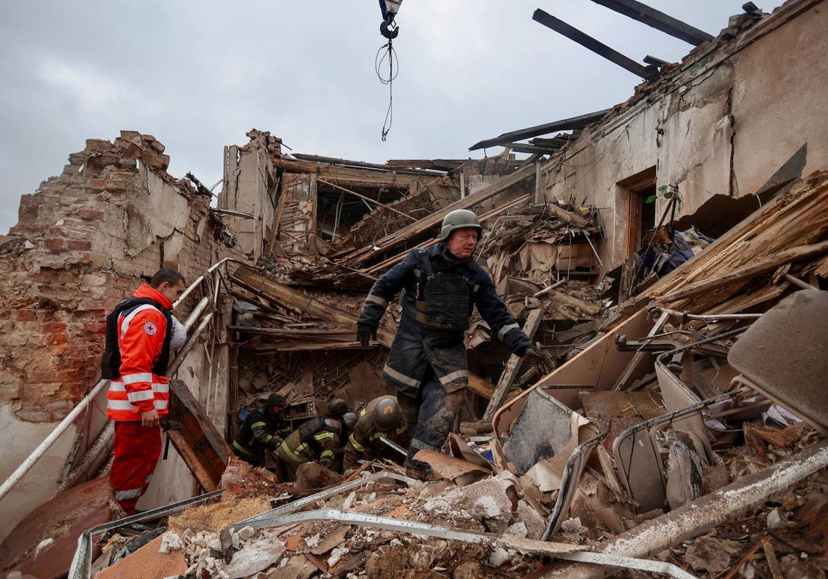 Dos rescatistas trabajan en un edificio del museo de Kupiansk, en Ucrania, destruido por un ataque con misiles rusos