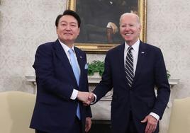 Biden y Yoon Suk Yeol se estrechan las manos antes del encuentro.