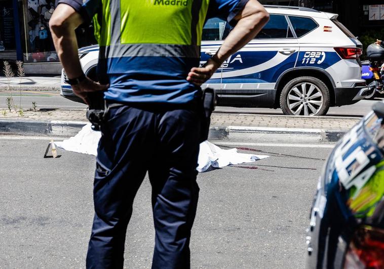 Un agente de la policía frente a una de las víctimas fallecidas en un atropello en el Paseo de Extremadura