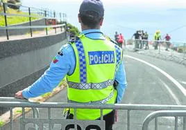 Un policía portugués hace guardia tras una valla que cierra el paso a los curiosos.