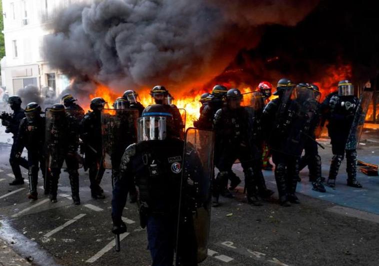 Las fuerzas de seguridad toman posiciones en una calle de París en la que fue incendiado un aparcamiento de bicicletas.