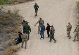 Agentes interceptan a migrantes que acababan de cruzar el río Bravo en su camino de México a Estados Unidos.