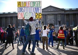 Un grupo de personas protesta en la plaza del Louvre antes de la decisión del Consejo Constitucional.