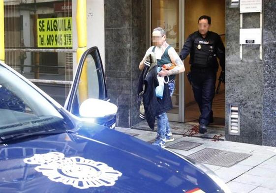 El presunto agresor sale detenido del portal. En el suelo, restos de sangre de la víctima.