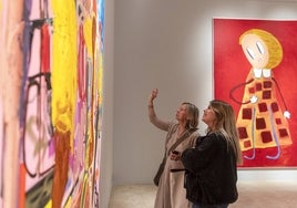 Dos mujeres observan unos de los cuadros de la exposición.