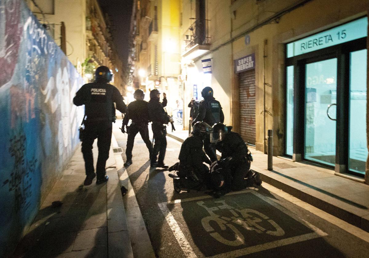 Miembros de los Mossos d´Esquadra detienen a uno de los participantes en la manifestación del colectivo okupa en el centro de Barcelona.