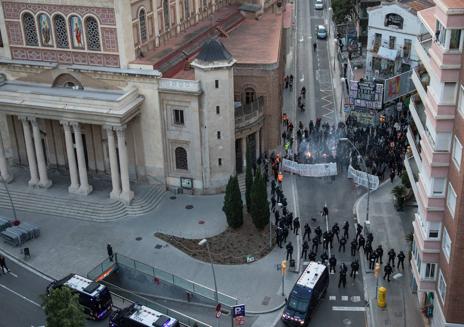 Imagen secundaria 1 - En la imagen superior los antidisturbios de los Mossos vigilan la marcha prookupación de este jueves en previsión de incidentes violentos; denajo, vista general de la zona de Barcelona donde están situados los inmuebles afectados, la Ruina y el Kubo; por último, detalle de una de las casas okupadas.