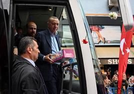 El presidente turco, Recep Tayyip Erdogan, reparte muñecas durante un acto electoral en Estambul.