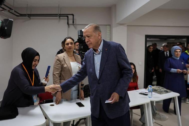 Erdogan saluda a la presidenta de la mesa electoral de Estambul en la que depositó su voto.