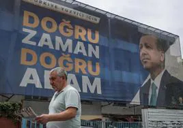 Un hombre camina frente a un cartel electoral de Erdogan en una calle de Estambul.