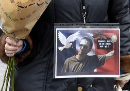 Una mujer sostiene una foto de Samuel Paty durante un homenaje celebrado en París en octubre de 2020.