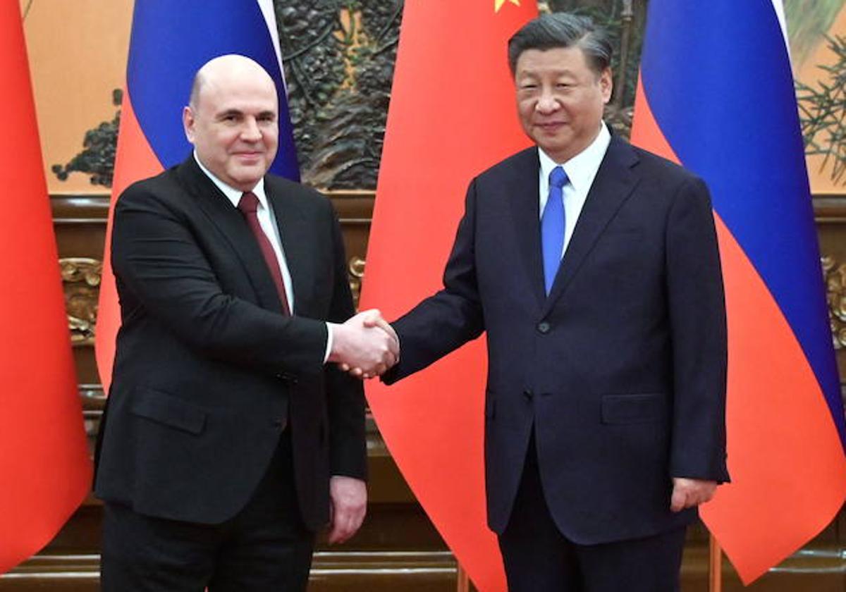 Mikhail Mishustin y Xi Jinping se saludan antes de su reunión en Pekín.