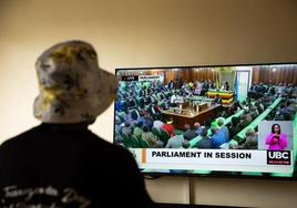 Una transexual sigue en televisión la aprobación de la ley que criminaliza la homosexualidad en Uganda.