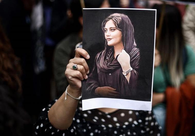 Una manifestante sostiene un retrato de Mahsa Amini durante una protesta.