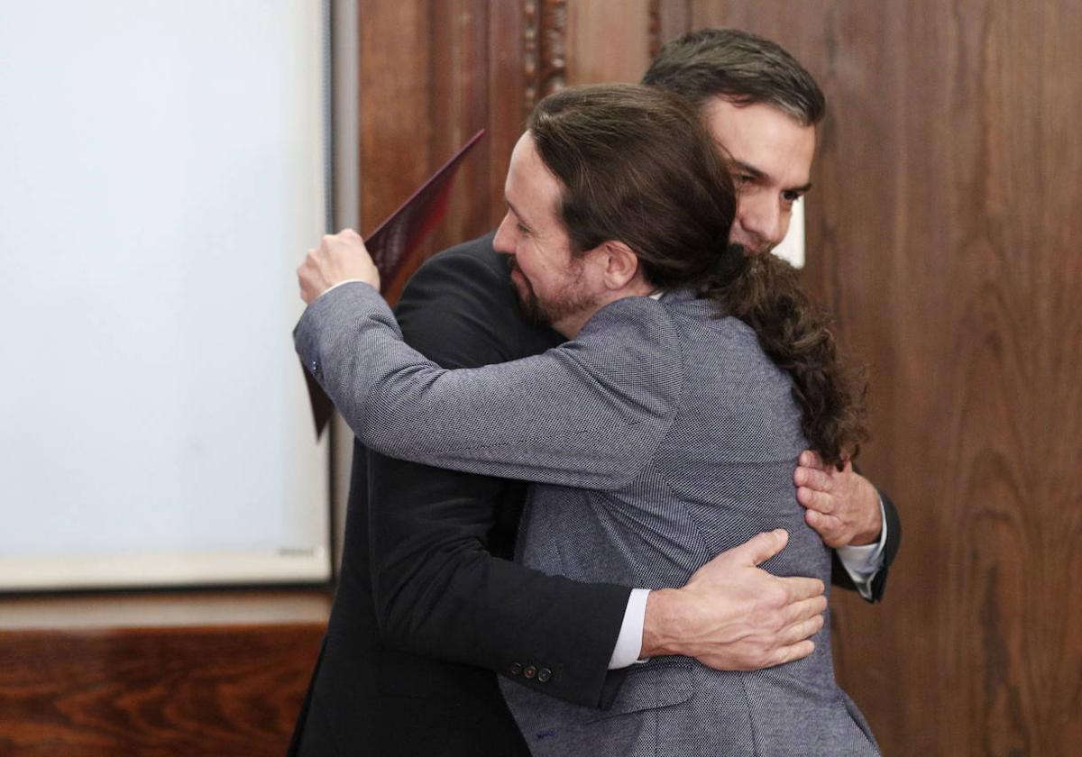 Pedro Sánchez y Pablo Iglesias se abrazan tras firmar el preacuerdo para el Gobierno de coalición.