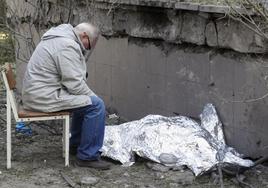 La dramática imagen muestra a un vecino de Kiev junto al cadáver de su mujer, una de las tres víctimas mortales del bombardeo ruso registrado este jueves sobre la capital ucraniana