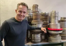 El periodista Pedro Santos, junto a un montón de latas del archivo de RTVE.